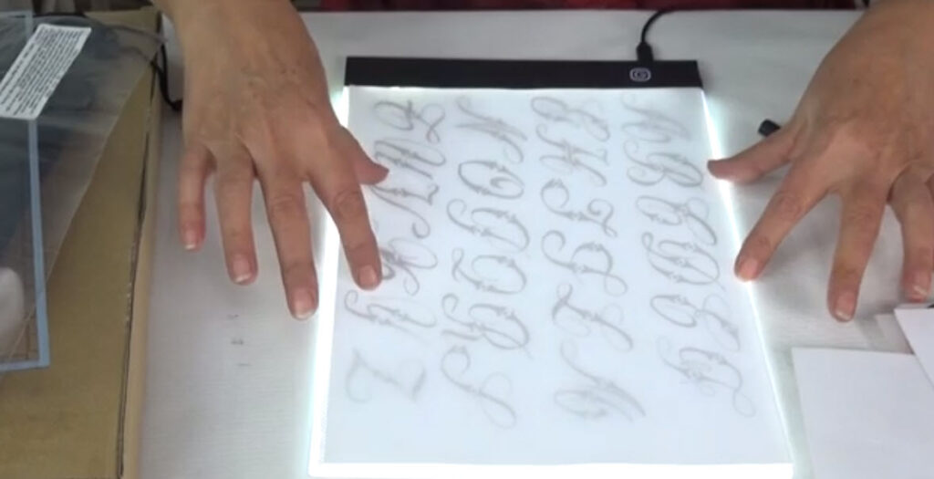 Practicando caligrafía con la mesa para calcar dibujos